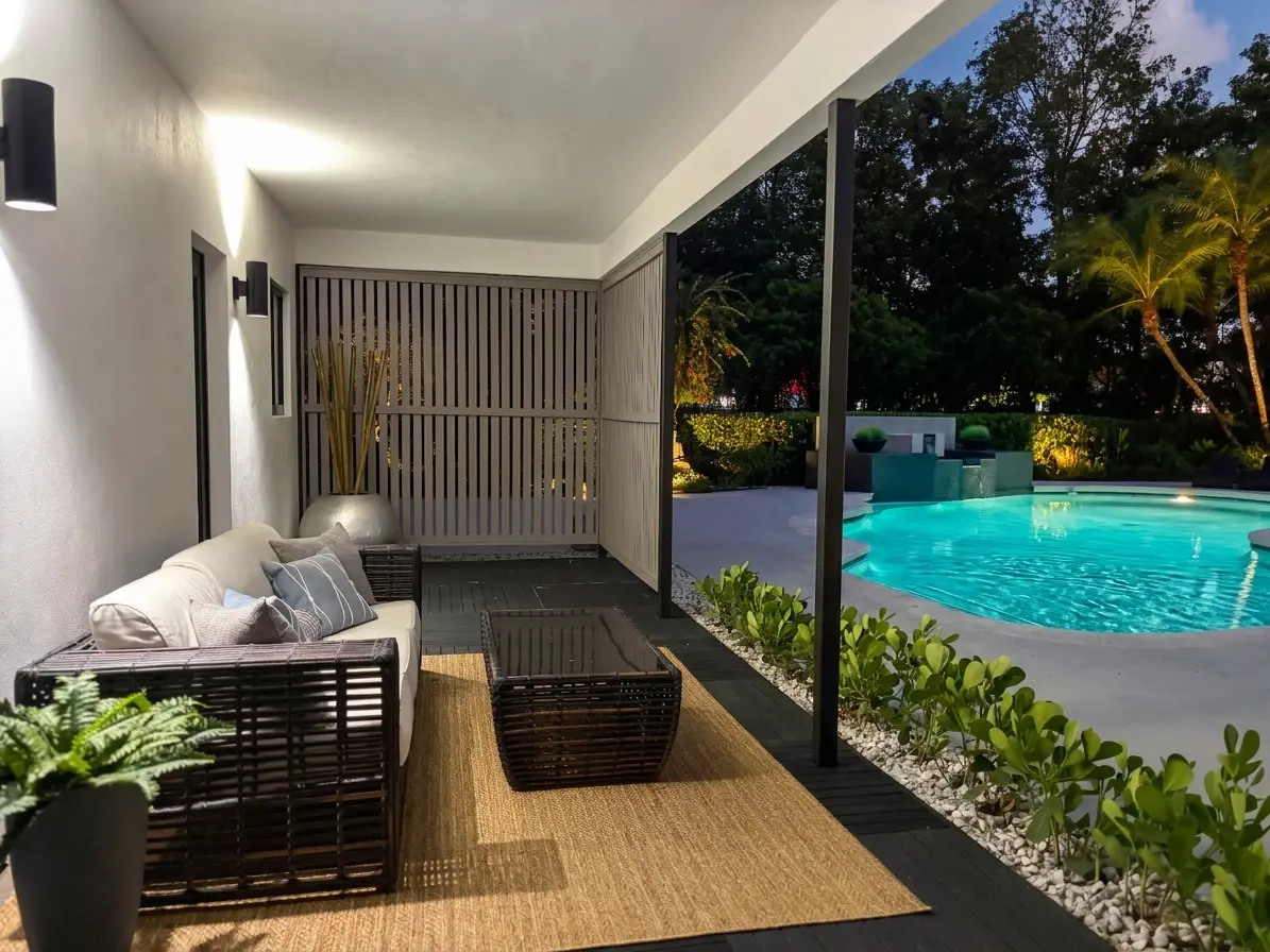 Covered patio lounge with pool view at evening