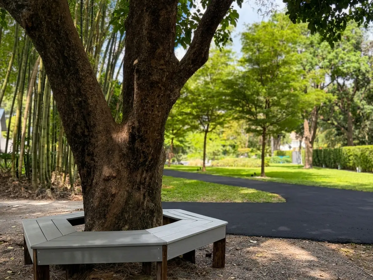 NE corner of grounds, bench seating around mature tree