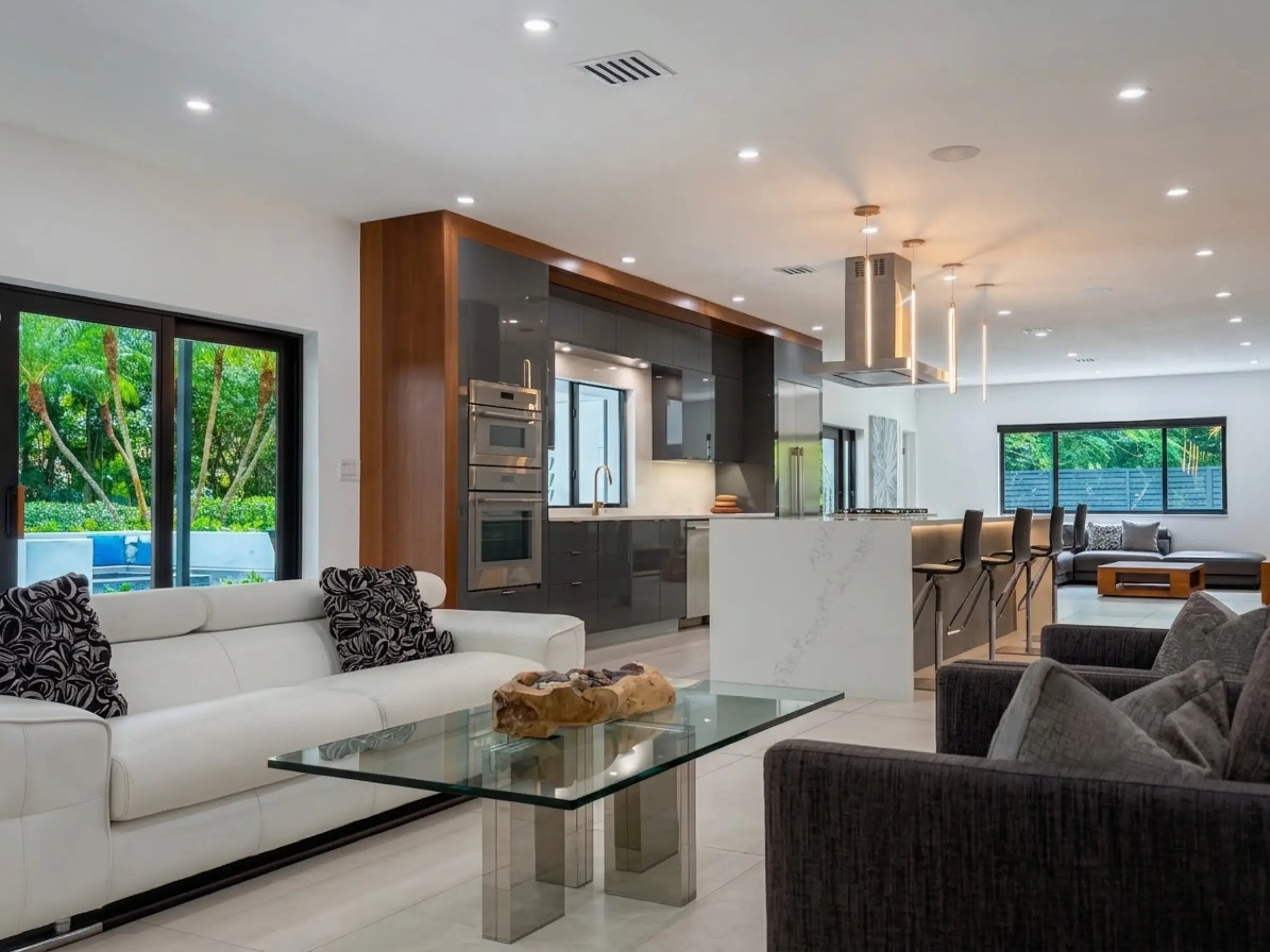 Living room with floor-to-ceiling impact glass, large-format porcelain tile, and open floor plan