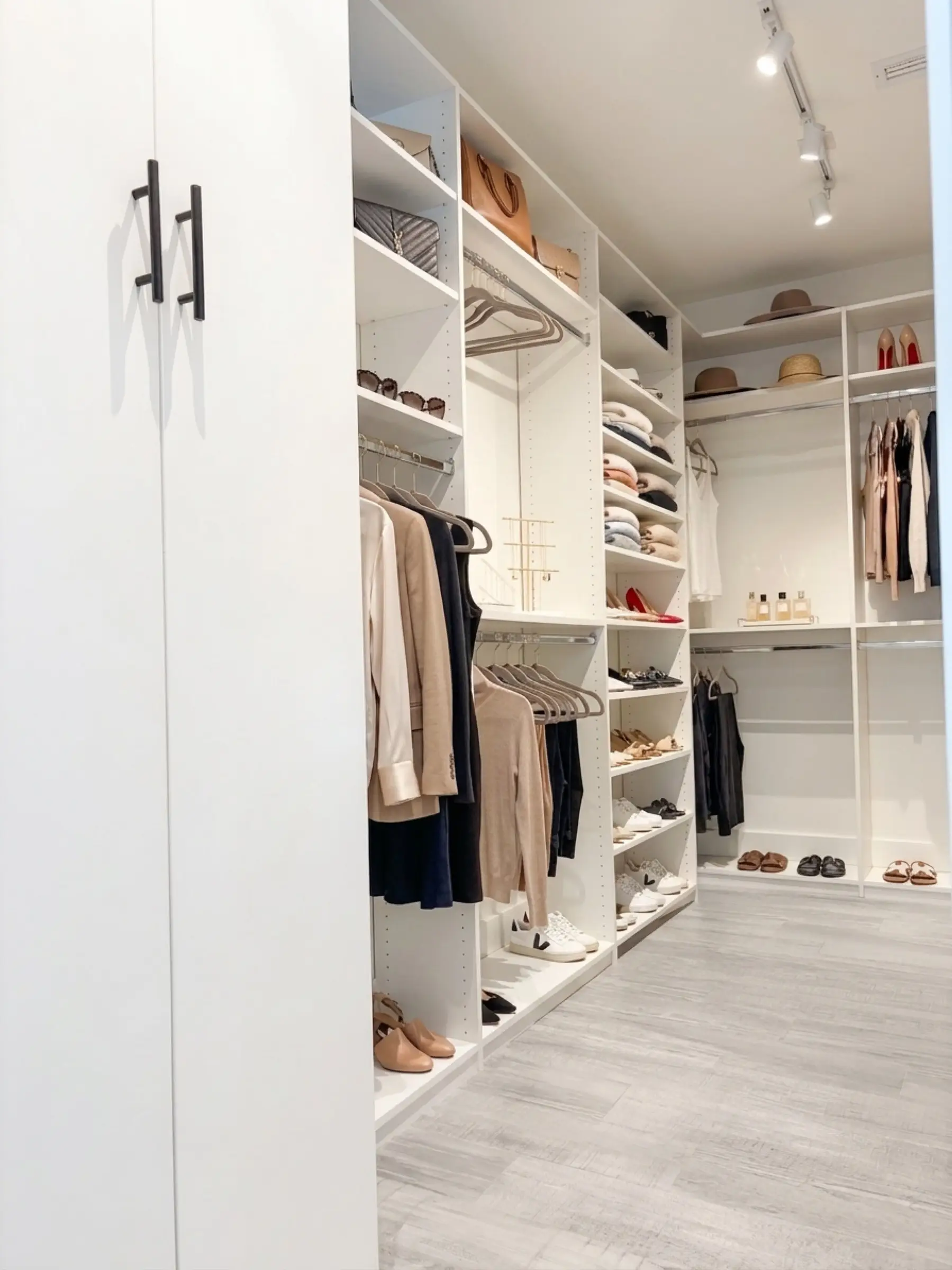 Primary suite walk-in closet with custom millwork